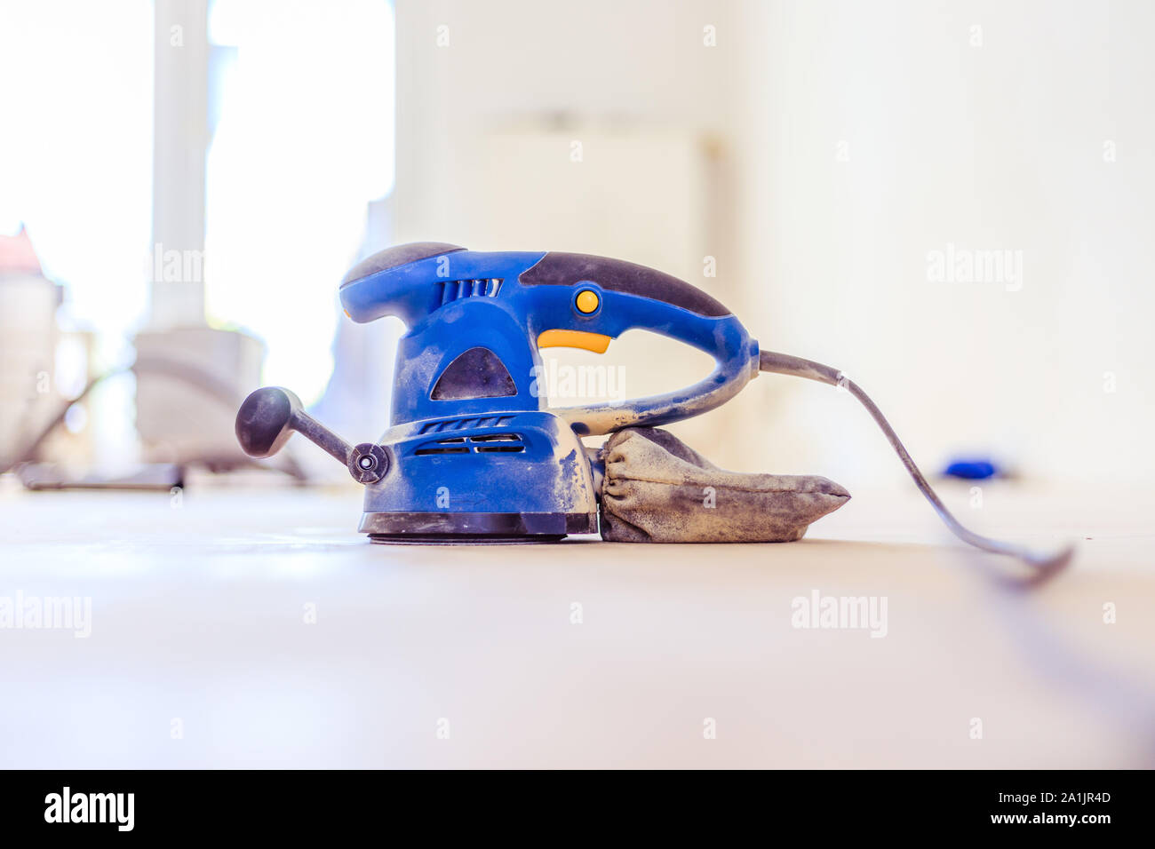 In prossimità di una macchina levigatrice strumento di potere per DIY su pavimento in parquet Foto Stock