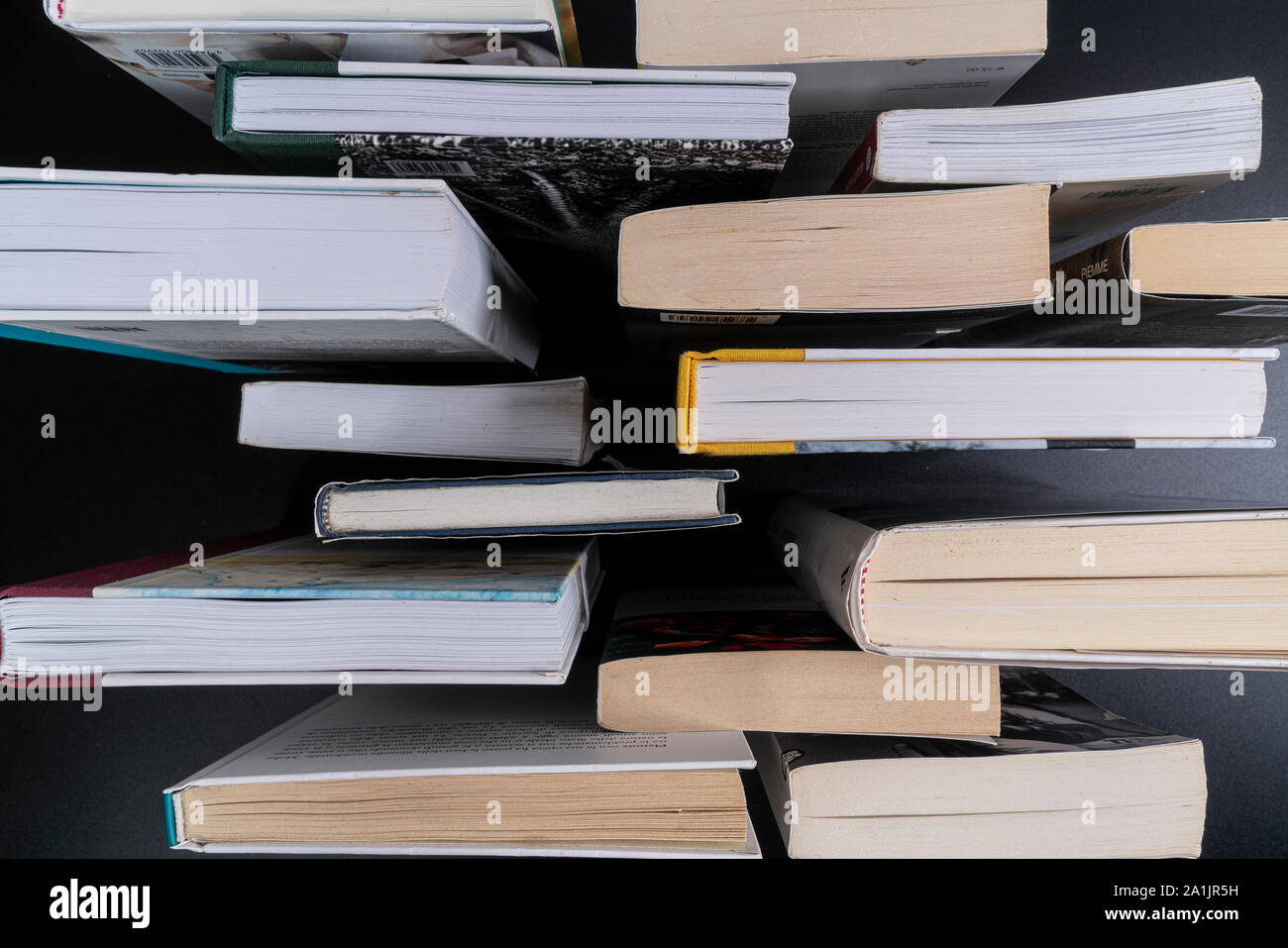 Una serie di libri su una superficie nera visto da sopra Foto Stock