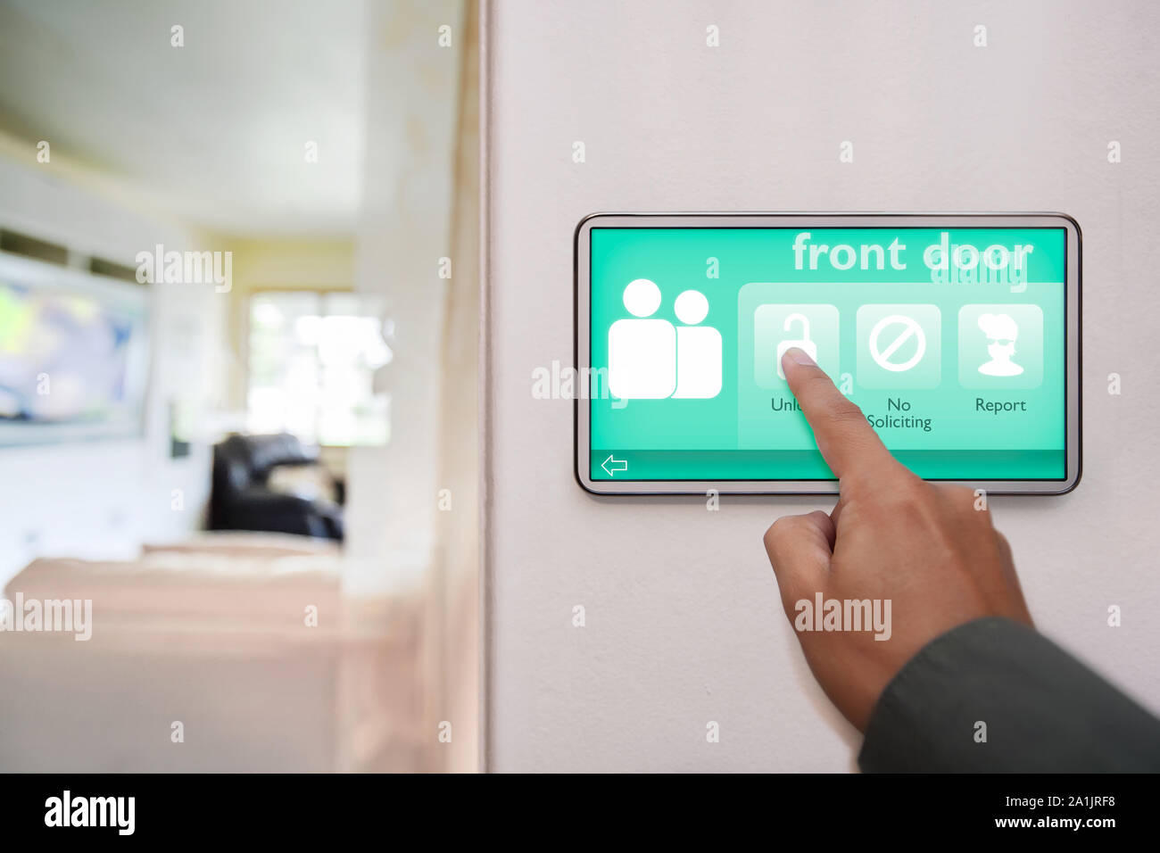 Proprietario di casa lo sblocco dello sportello anteriore della casa, utilizzando un dispositivo touchscreen per il controllo di tutti i connessi smart home caratteristiche. Foto Stock