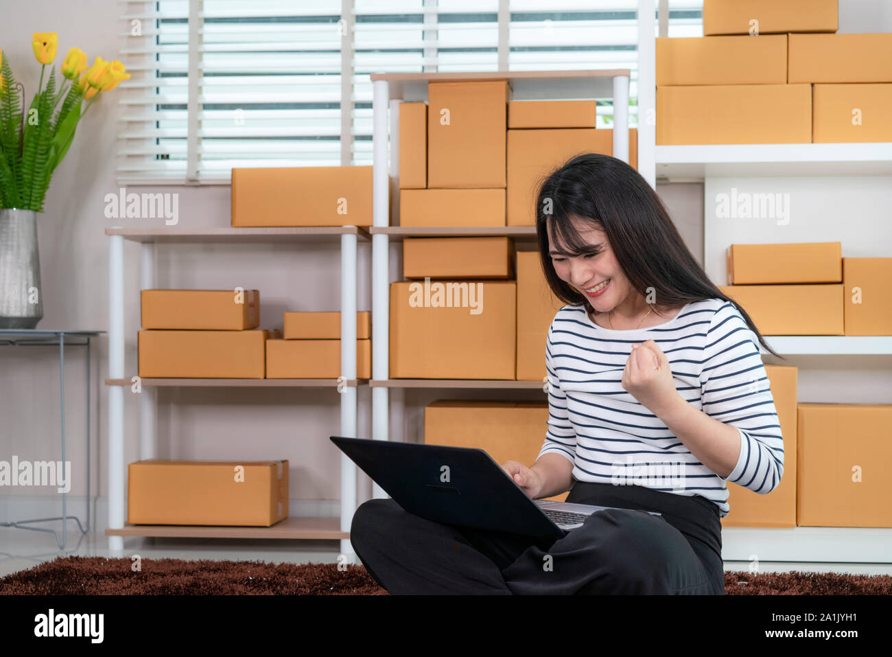 Affascinante bella asiatica adolescente proprietario business donna seduta in piano per lo shopping online, cercando ed entusiasti in ordine al computer portatile e con office eq Foto Stock