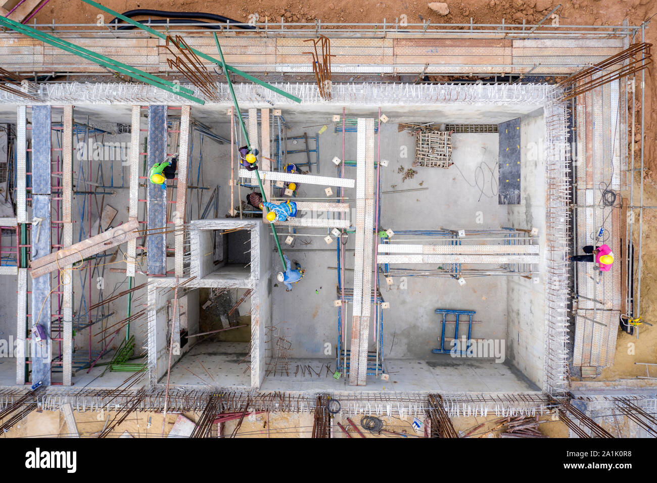 Vista aerea del gruppo di lavoratore edile edificio nel sito in costruzione. Ingegneria civile, industriale per lo sviluppo di un progetto, torre seminterrato foundati Foto Stock