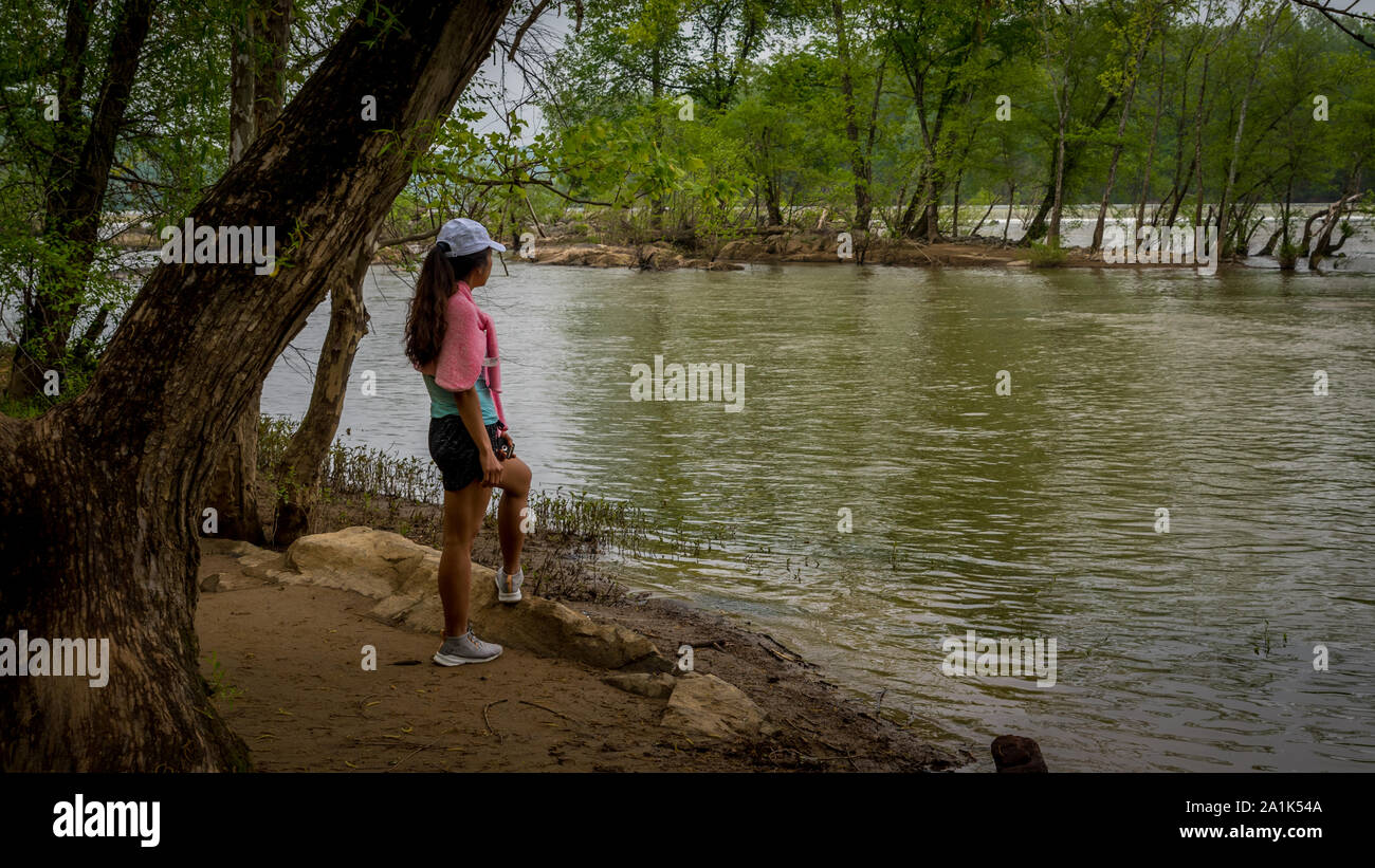 Medioevo donna con rosa maglione in piedi dal fiume sul sentiero nel Parco Nazionale Foto Stock