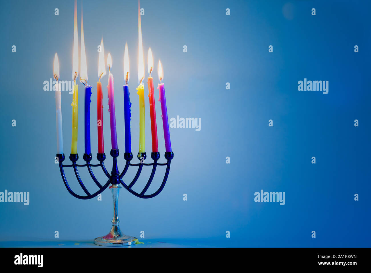 Immagine della festa ebraica Hanukkah sfondo con menorah candelabri tradizionali e masterizzazione di candele colorate .Copia spazio per il testo. Foto Stock