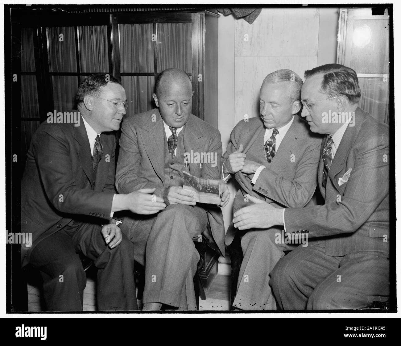 Nuovi capi del Van Sweringen RR Impero. Washington, 6 maggio. Il senatore Wheeler del senato del comitato ha iniziato oggi ha iniziato inchiesta dell'ultimo trasferimento del controllo del Van Sweringen Railroad Impero. Due settimane fa George Ball venduto il controllo a tre broker di New York ovvero giovani, Kobe e Co. che sono strettamente identificati con la General Motors e Du Pont interessi. Da sinistra a destra in un huddle prima della sessione sono: Walter S. Orr, avvocato per gli intermediari e i nuovi proprietari Allen P. Kirby; Robert R. giovani; e Frank F. Kolbe, 5/6/1937 Foto Stock