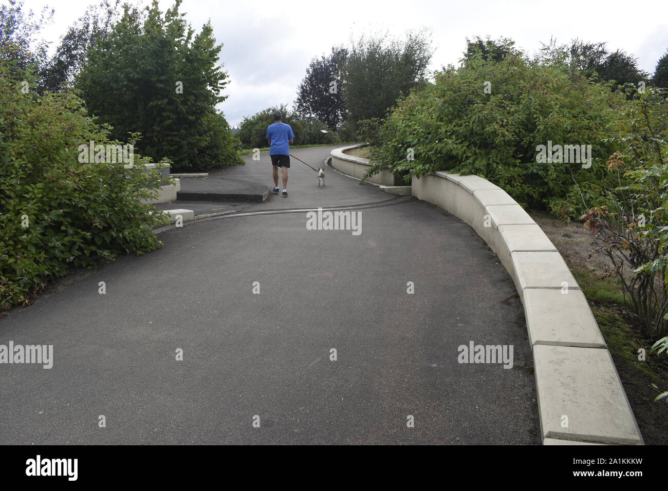 Una mattina walker e il suo cane testa fino al lato nord, passaggio di Vancouver ponte di terra. Foto Stock