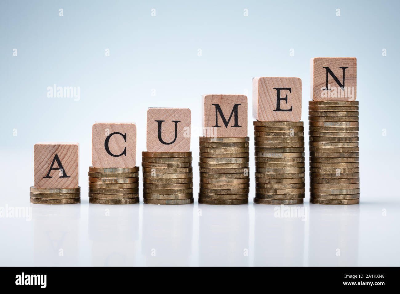 Aumentando il grafico delle monete impilate con acume di blocco di testo sulla riflettente Sfondo bianco Foto Stock