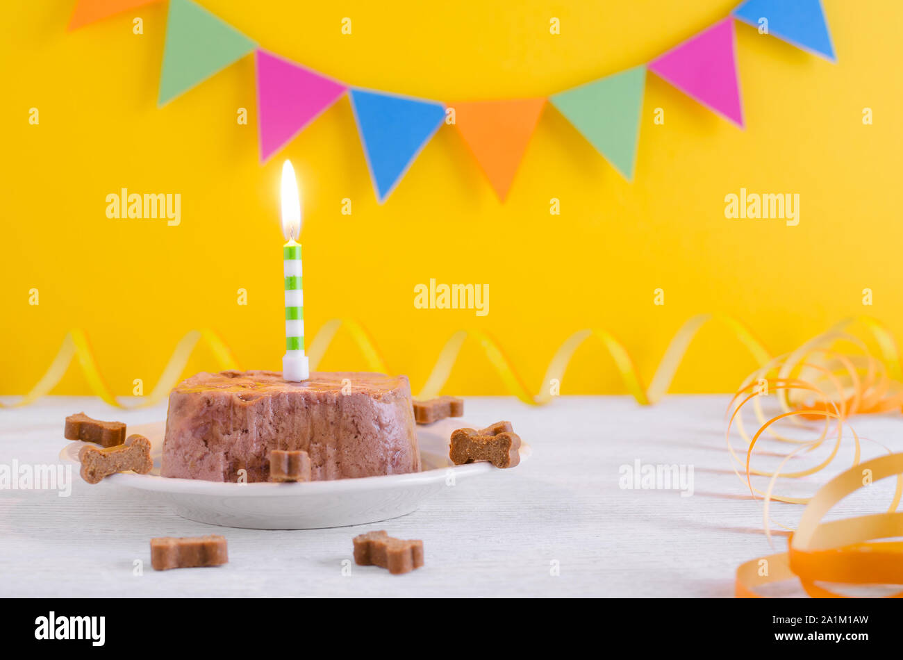 Buon compleanno torta per il cane da alimento umido e tratta con candela sulla parte gialla sullo sfondo Foto Stock