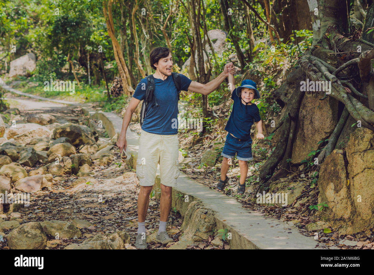 Padre e figlio camminano lungo la strada forestale Foto Stock