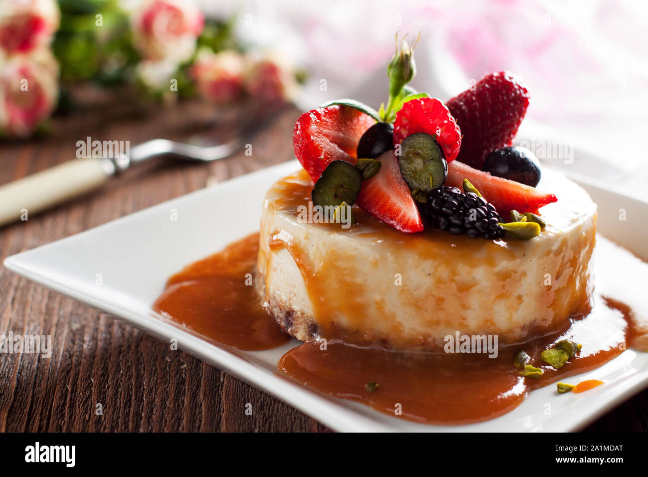 Materie vegan cheesecake con sirup di caramello e frutti di bosco freschi Foto Stock