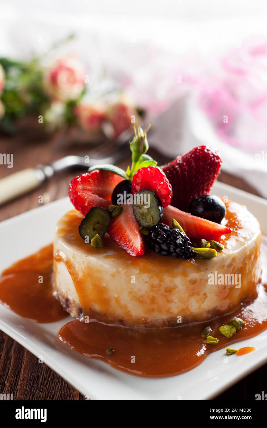 Materie vegan cheesecake con sirup di caramello e frutti di bosco freschi Foto Stock
