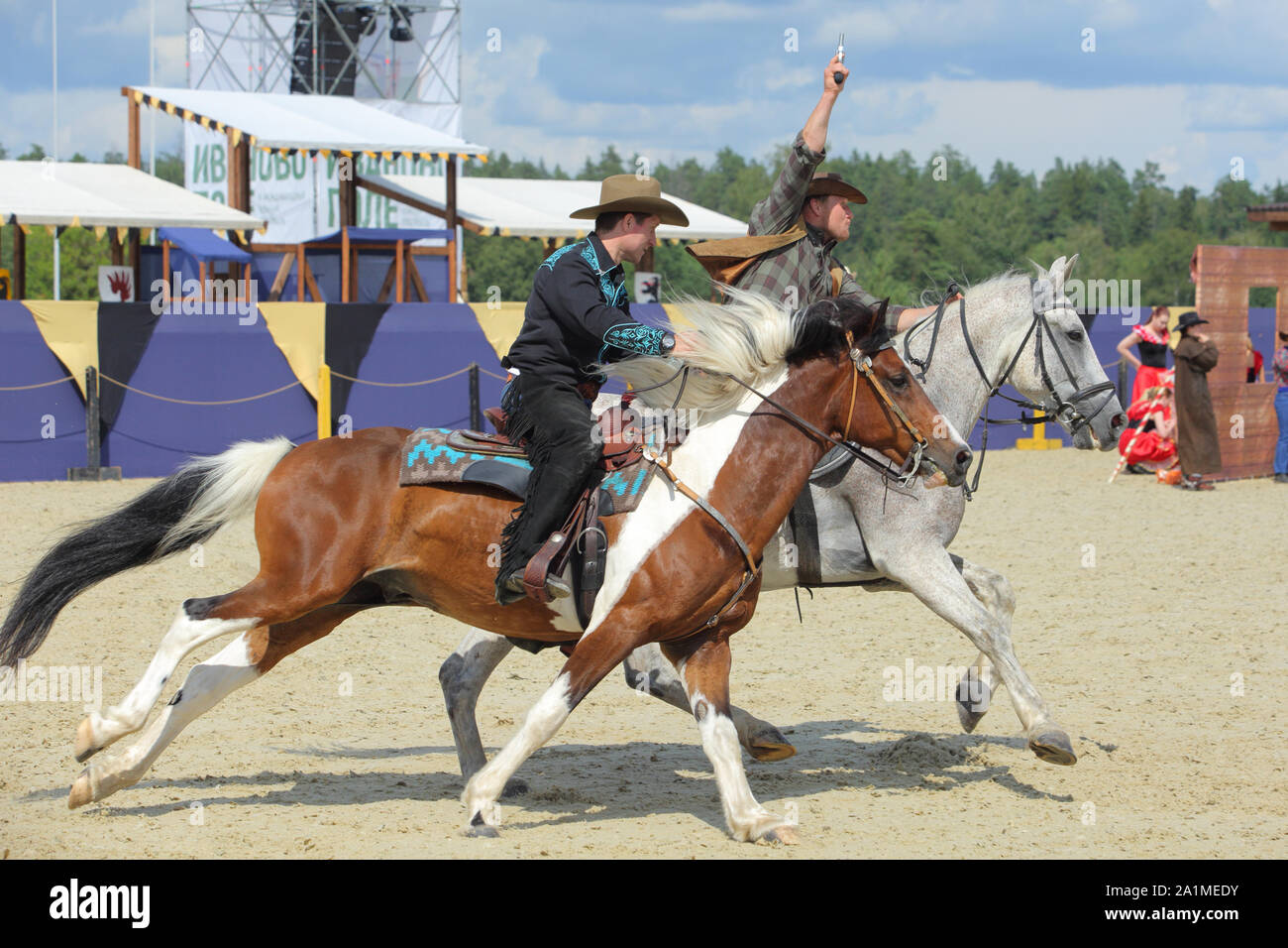 Cowboy a cavallo al galoppo completo con la pistola in mano Foto Stock