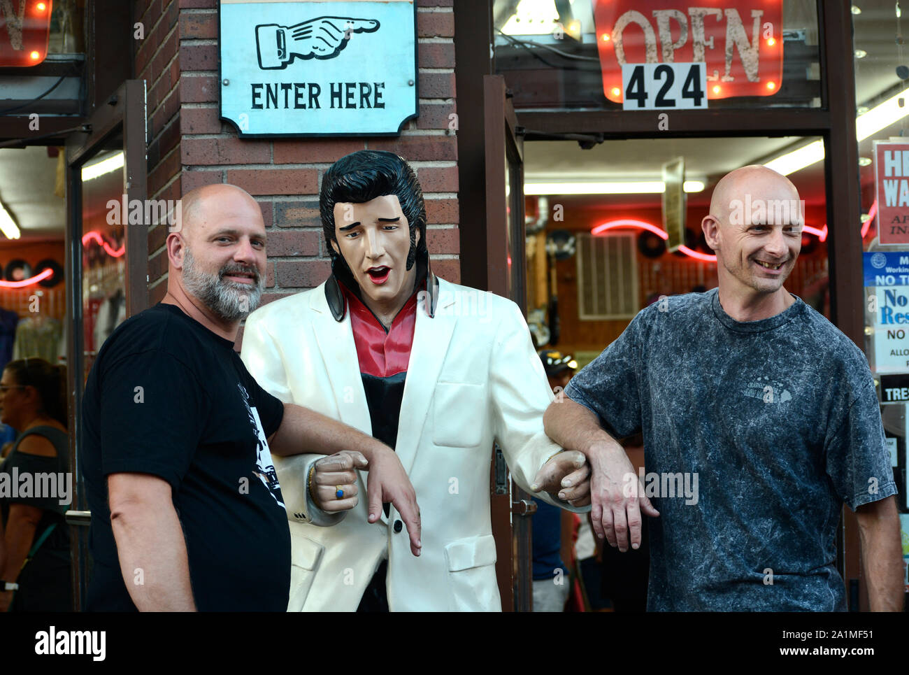 Due uomini hanno posato con una dimensione di vita statua di Elvis Presley mentre visitano il quartiere dei divertimenti di Nashville, Tennessee Foto Stock