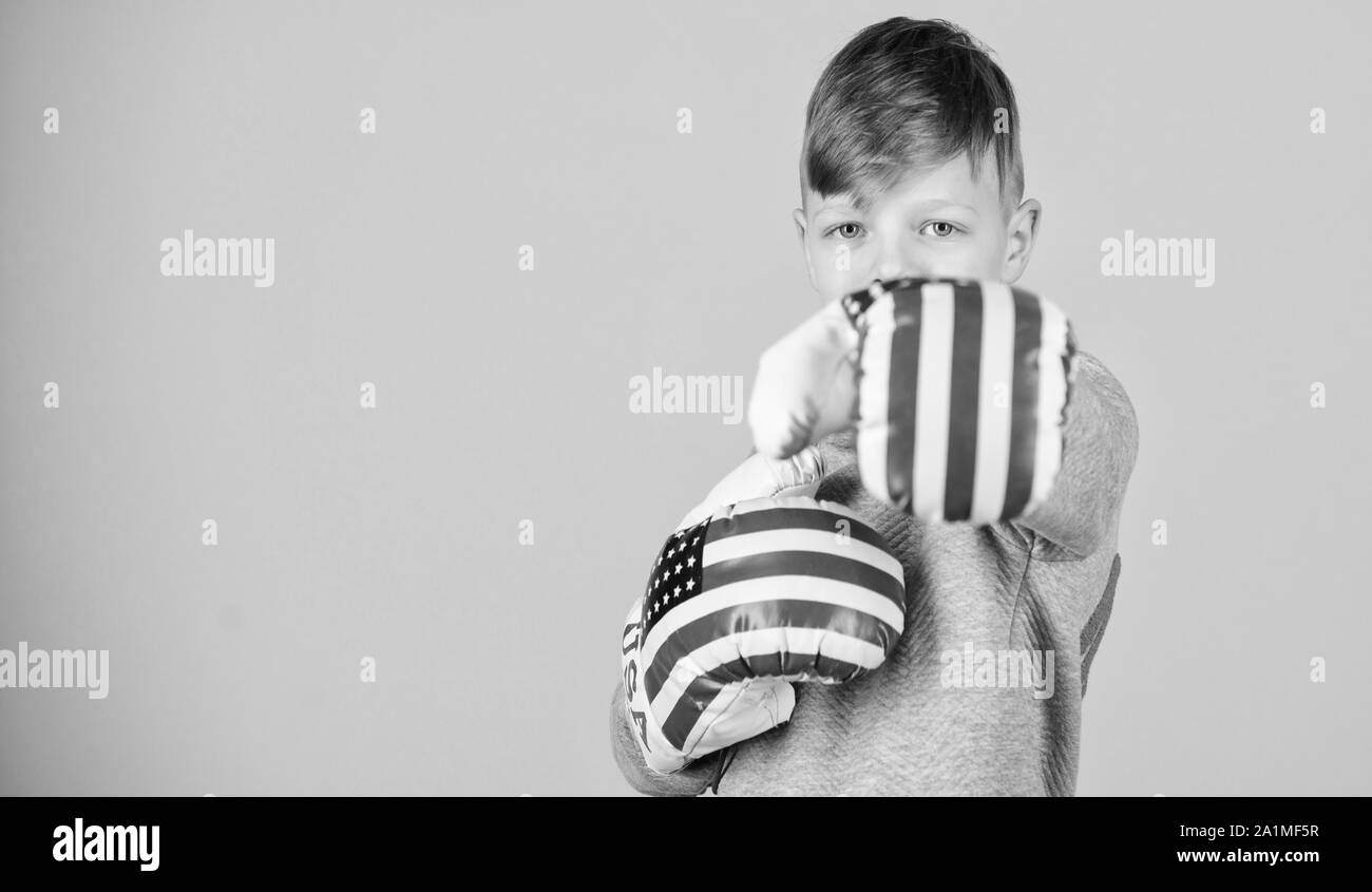 Allenamento di piccolo ragazzo boxer. Dieta Fitness. energia salute. punzonatura di knockout. Attività dell infanzia. Sport di successo. abbigliamento moda. usa il giorno di indipendenza. Bambino felice sportivo in guantoni da pugilato. Foto Stock