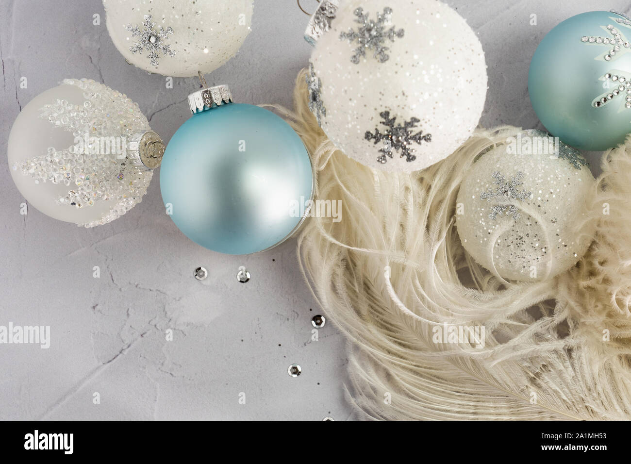 Messa a fuoco selettiva di piume di struzzo e splendenti palla di Natale ornamenti in bianco e pallido aqua su intonaco sfondo per il concetto di angelo ali e Foto Stock