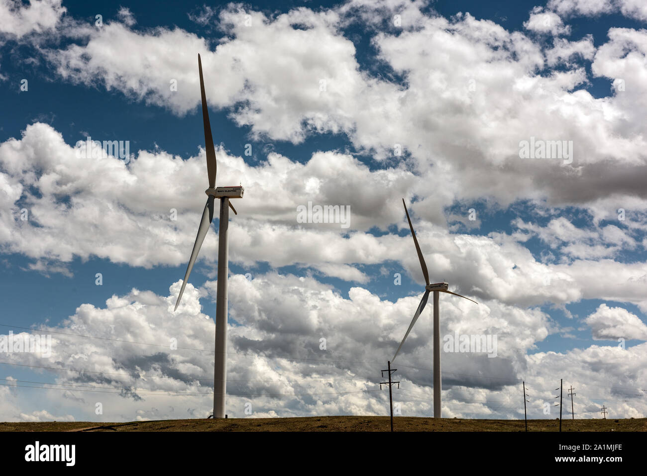 Poli di vecchio e di nuovo in aumento in Huerfano County, Colorado. I vecchi supportano cavi telefonici. Quelli nuovi trasportare enormi turbine eoliche Foto Stock