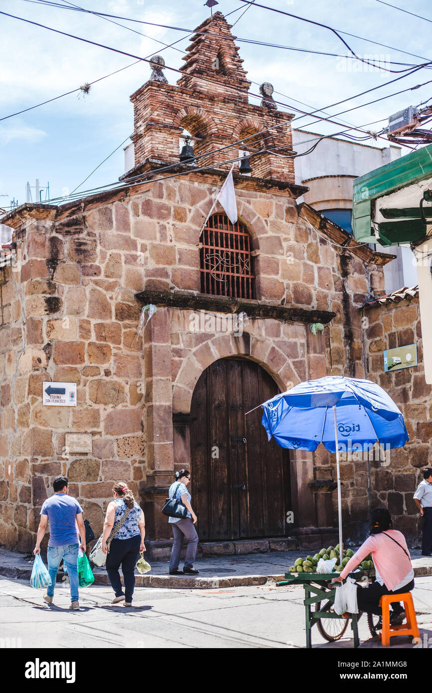 Tipica colombiana per angolo di strada con una chiesa e frutta stallo in San Gil, Santander, Colombia Foto Stock
