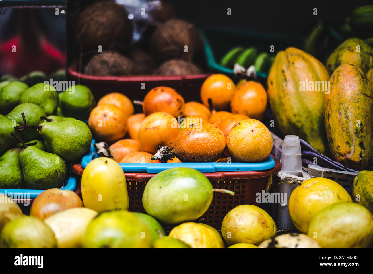 Cestini di esotica frutta colombiana in vendita su un mercato alimentare di stallo | succosa granadilla frutto della passione, curuba, guanabana, noci di cocco, pere e lulo Foto Stock