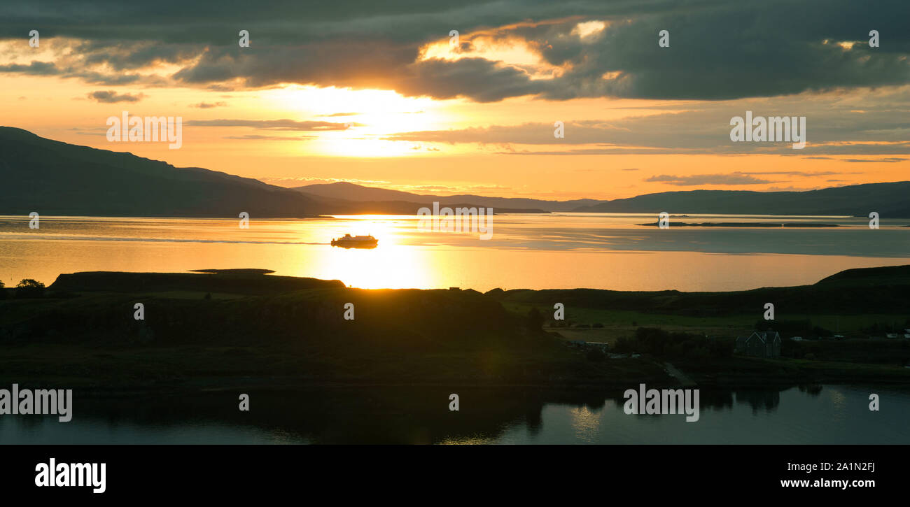 Tramonto sul mare dal pulpito Hill, Oban. Costa ovest della Scozia. Isola di Kerrera in primo piano e traghetto barca a vela da Isle of Mull retroilluminato in backgroun Foto Stock