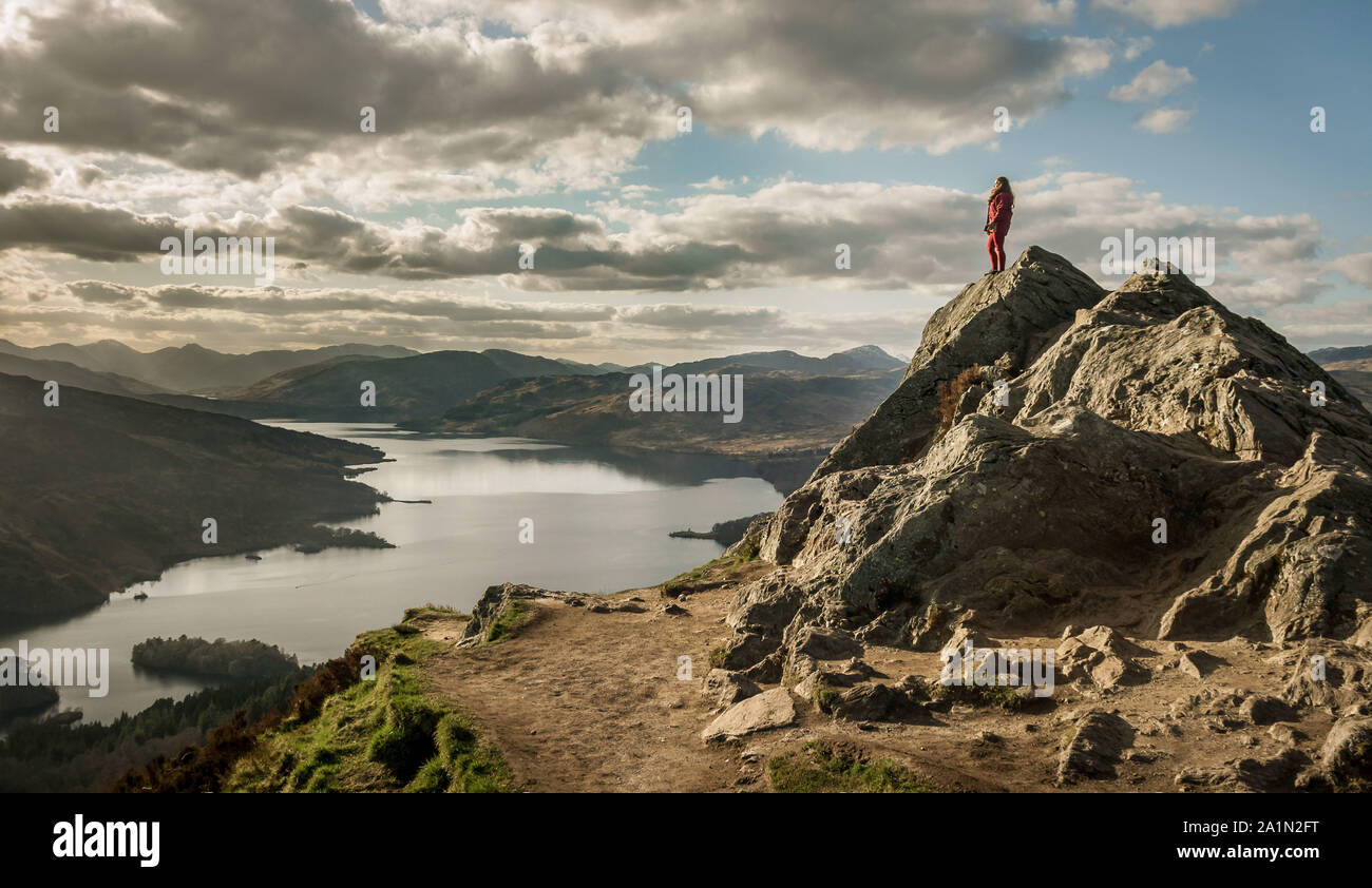 Vista del Loch Katrine dal picco di ben un'an con una donna in piedi in cima alla montagna. Loch Lommond e il Trossachs National Park.Scozia Scotland Foto Stock