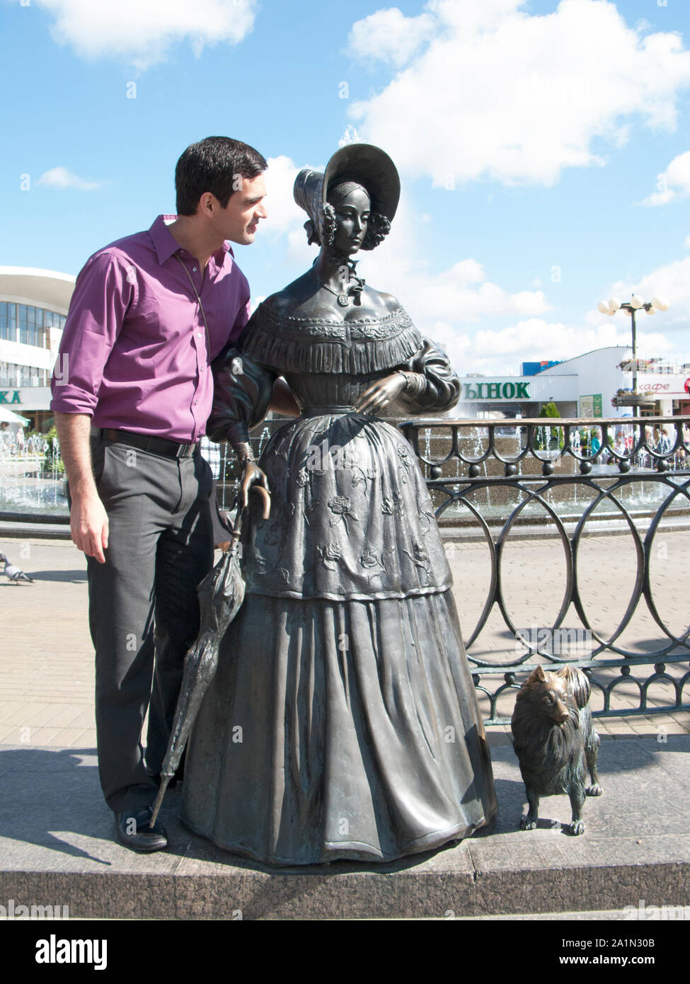 Un turista pone con il 'Chekhov signora con il suo cane' scultura da Vladimir Ivanovich Zhbanov a Minsk Foto Stock