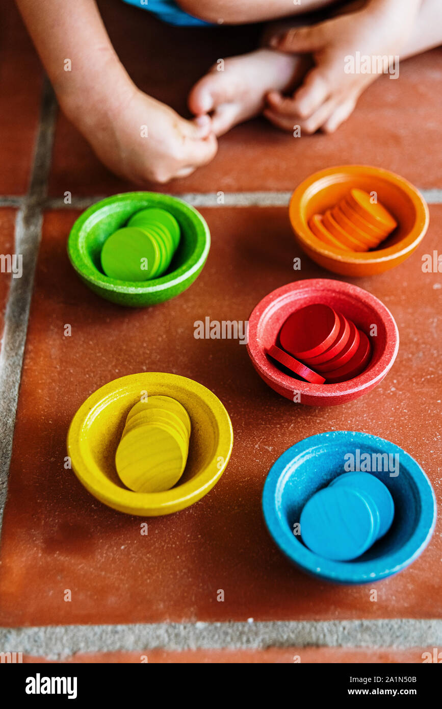 Serie di contenitori a forma di come ciotole di legno in diversi colori luminosi, montessori giochi didattici. Foto Stock