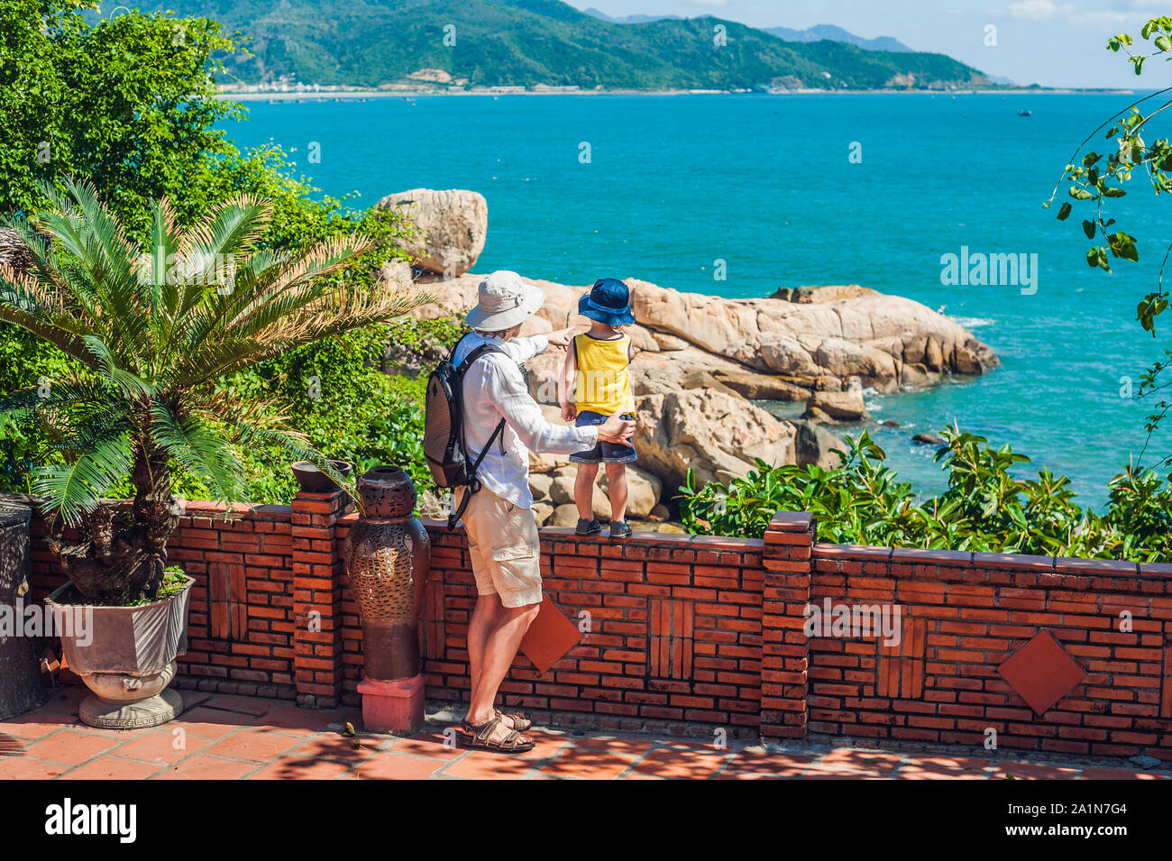 I viaggiatori del padre e del figlio guardano il capo di Hon Chong, pietra di giardino, destinazioni turistiche popolari a Nha Trang. Vietnam Foto Stock