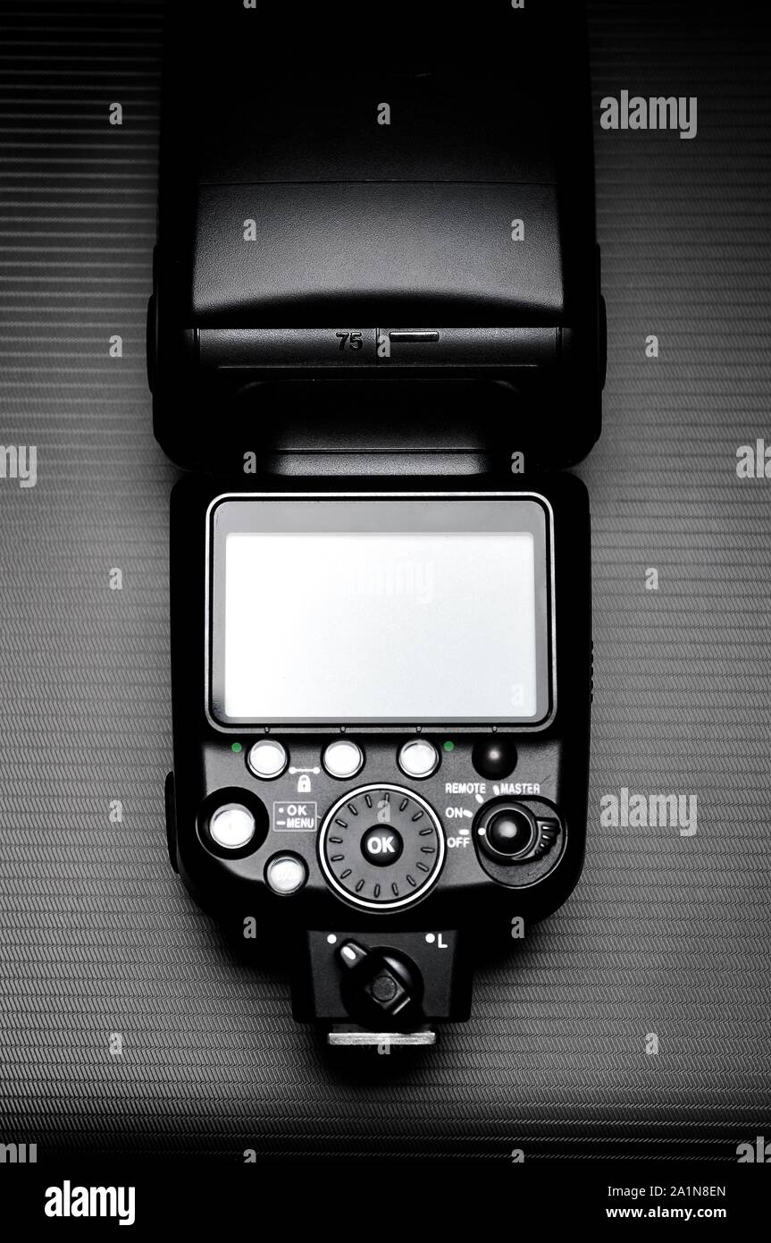 Esterno lampada a flash per fotocamera reflex digitale su sfondo scuro. Foto Stock