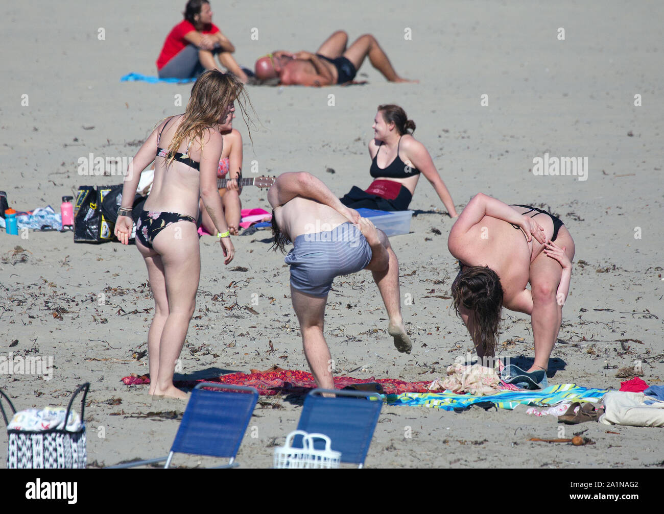 Uomo e donna paffuto in Twister pone sulla spiaggia Foto Stock
