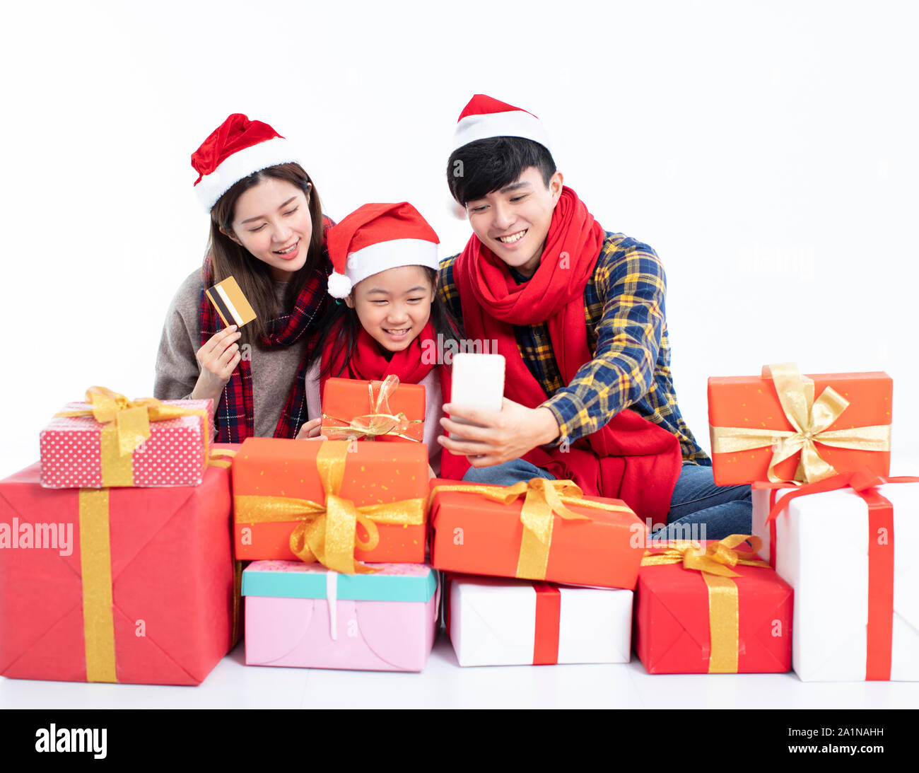 La famiglia felice shopping regalo di Natale da parte di smart phone Foto Stock