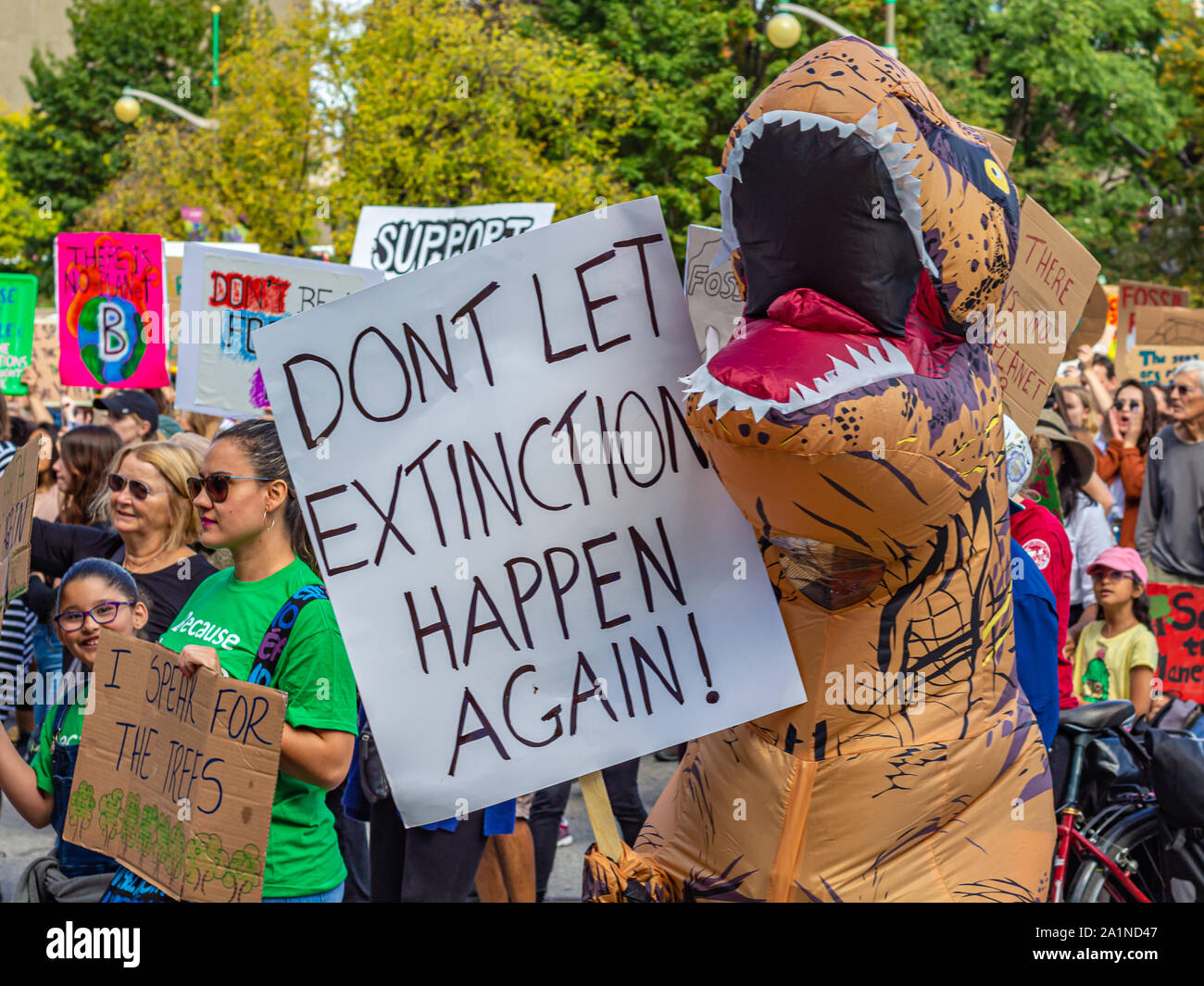 Al clima evento sciopero a Ottawa si unisce alla folla in un Tirannosauro Rex costume, con una lettura del segno "Non lasciare accadere di estinzione di nuovo!". Foto Stock