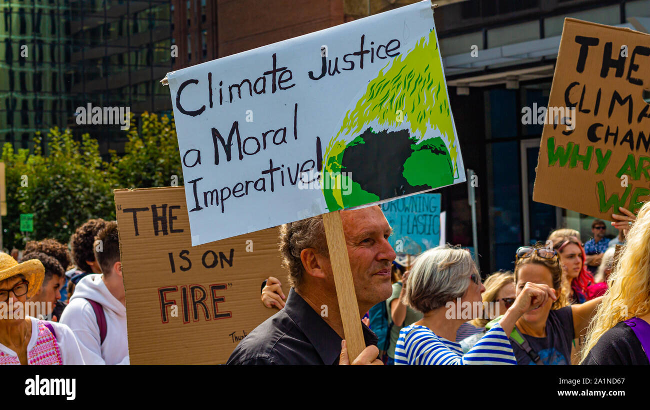 Un uomo fra la folla in sciopero clima evento in Ottawa detiene un segno di lettura, "giustizia climatica un imperativo morale!' Foto Stock