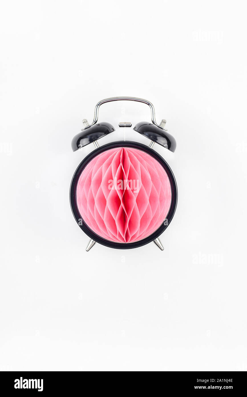 Compleanno o baby doccia invito alla festa del modello di scheda. Nero orologio sveglia con rosa di carta a nido d'ape sfera su sfondo bianco. Creative top concettuale Foto Stock