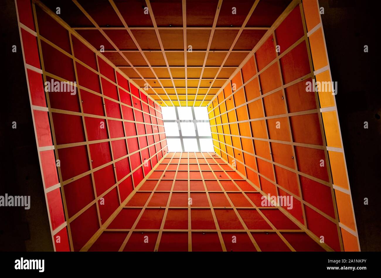 Prospettiva astratta della lobby verticale soffitto con lucernario e forte la geometria e la simmetria e colori drammatici come sfondo Foto Stock