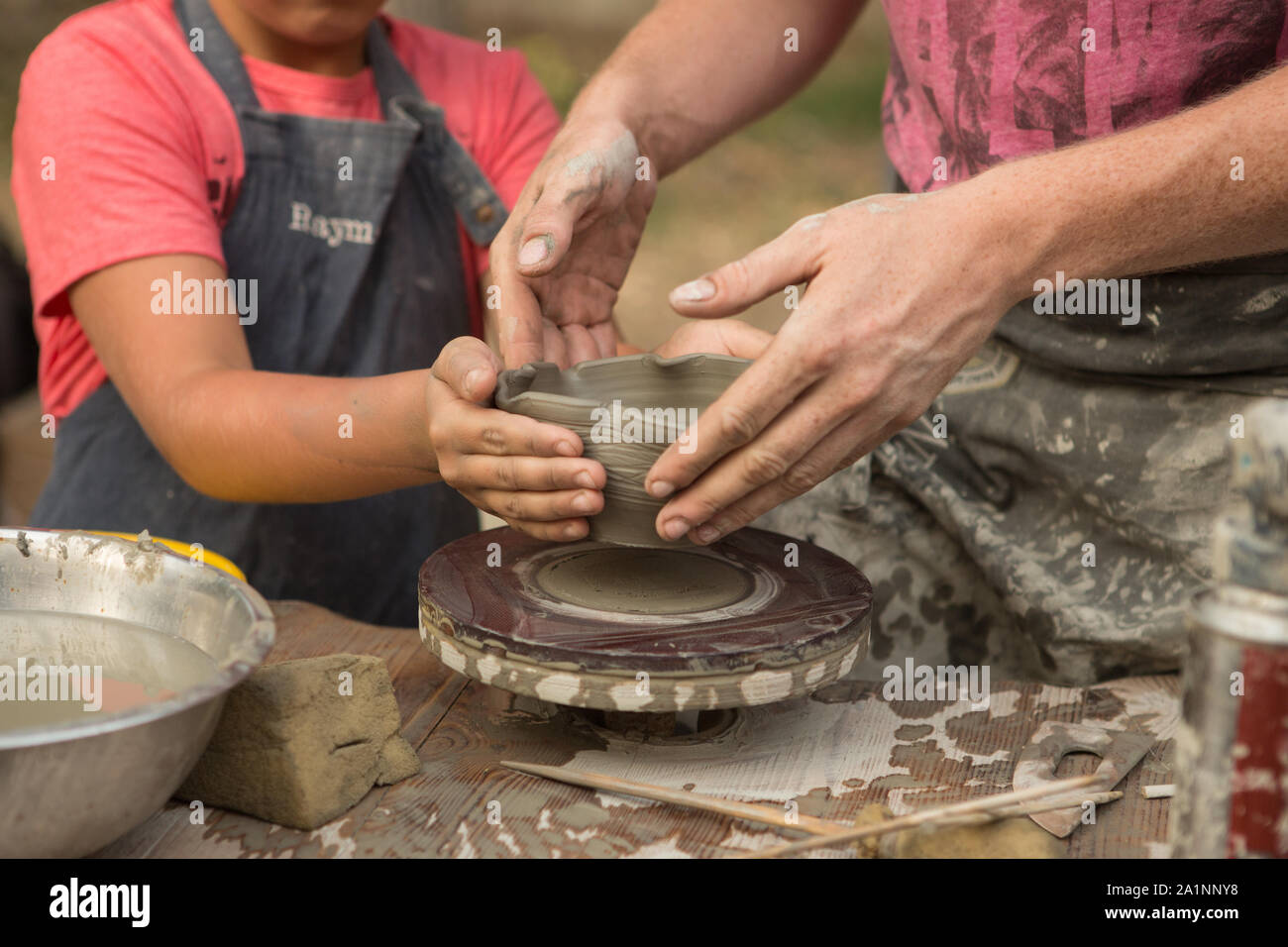 Di un vasaio canto scolpisce una pentola brocca di argilla su un Tornio del vasaio Foto Stock