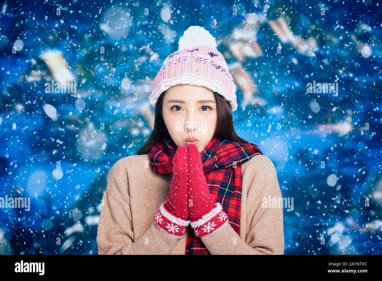 Giovane bella donna in abbigliamento invernale con la neve sullo sfondo Foto Stock