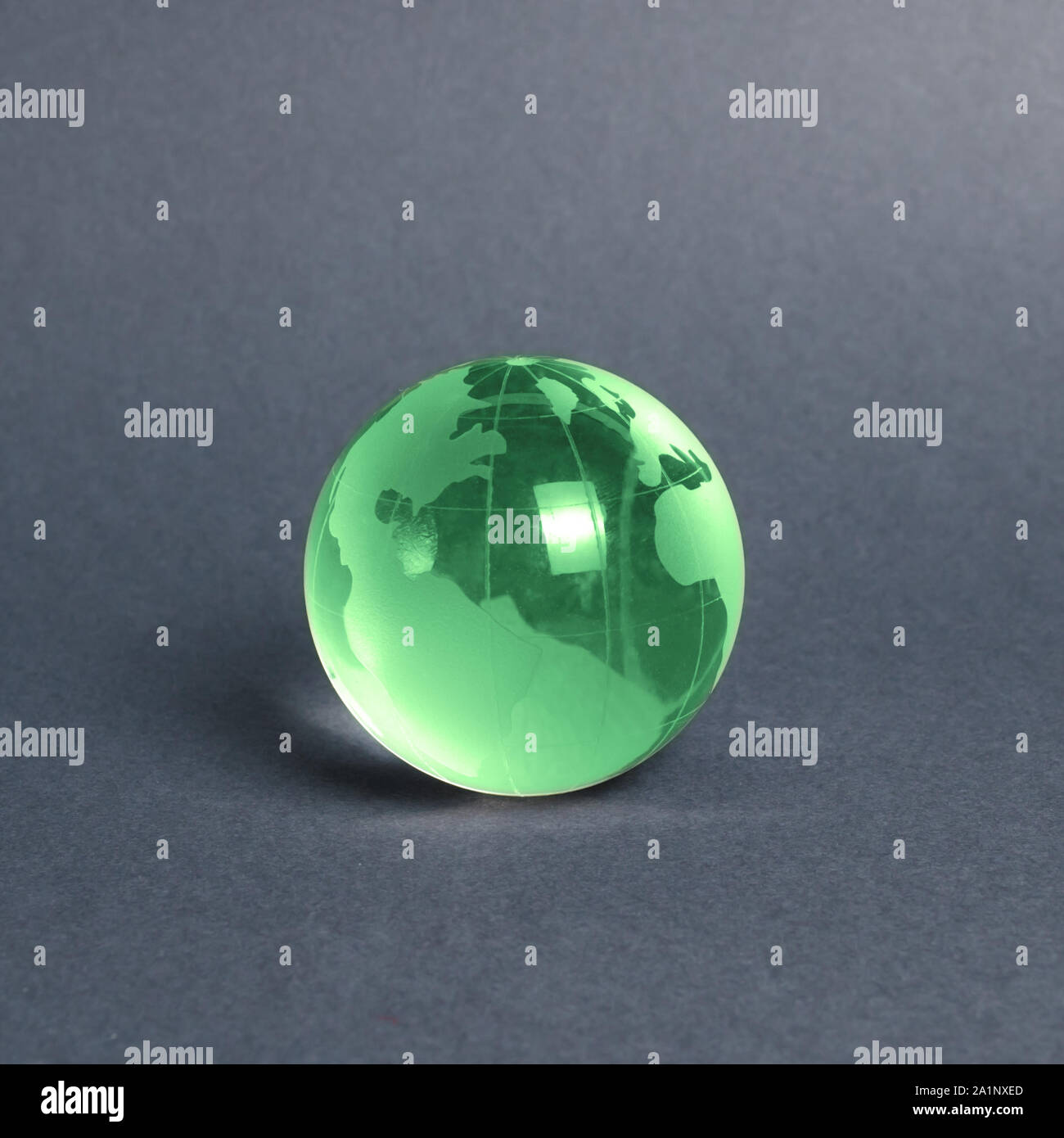 Vetro verde globo pianeta su sfondo grigio. La diplomazia internazionale. Lingue straniere. La globalizzazione e i mercati. La preservazione dell'ambiente Foto Stock