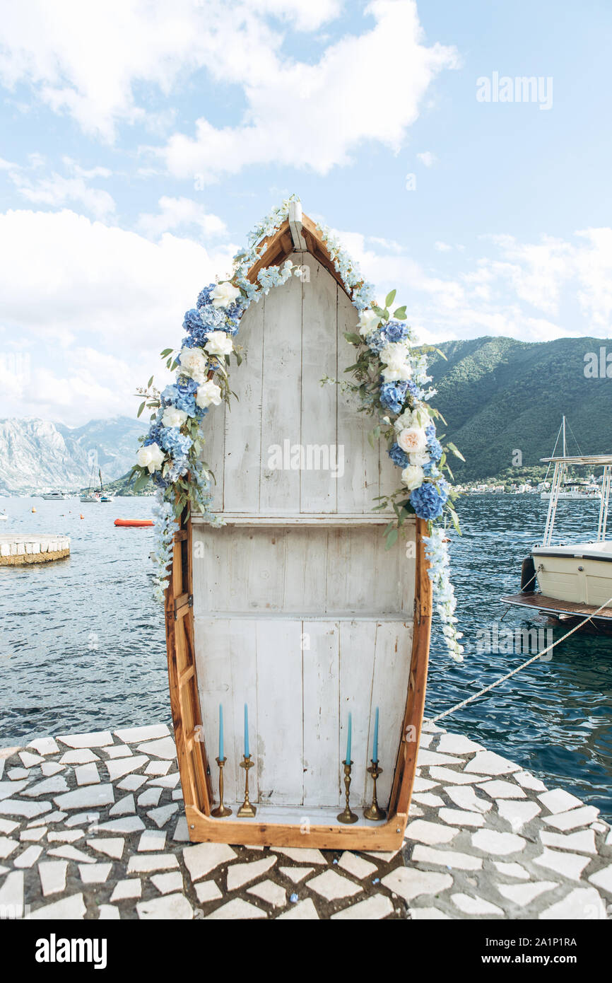 Una barca di legno decorate con fiori come un matrimonio arch sullo sfondo del mare. Preparazione per il matrimonio. Foto Stock