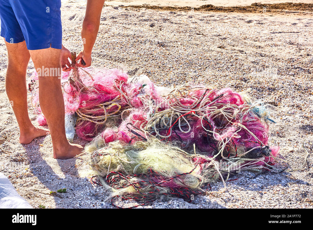 Un ingombro di reti da pesca corda di plastica e altri detriti lavato fino a una spiaggia costiera. Salvare il pianeta stock foto. Foto Stock