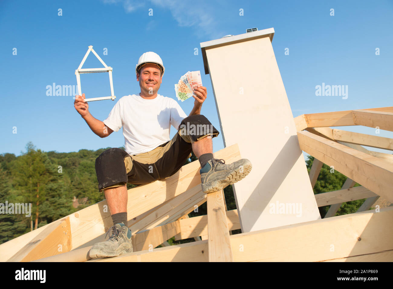 Giovane uomo è felice con la nuova casa e denaro nelle sue mani Foto Stock