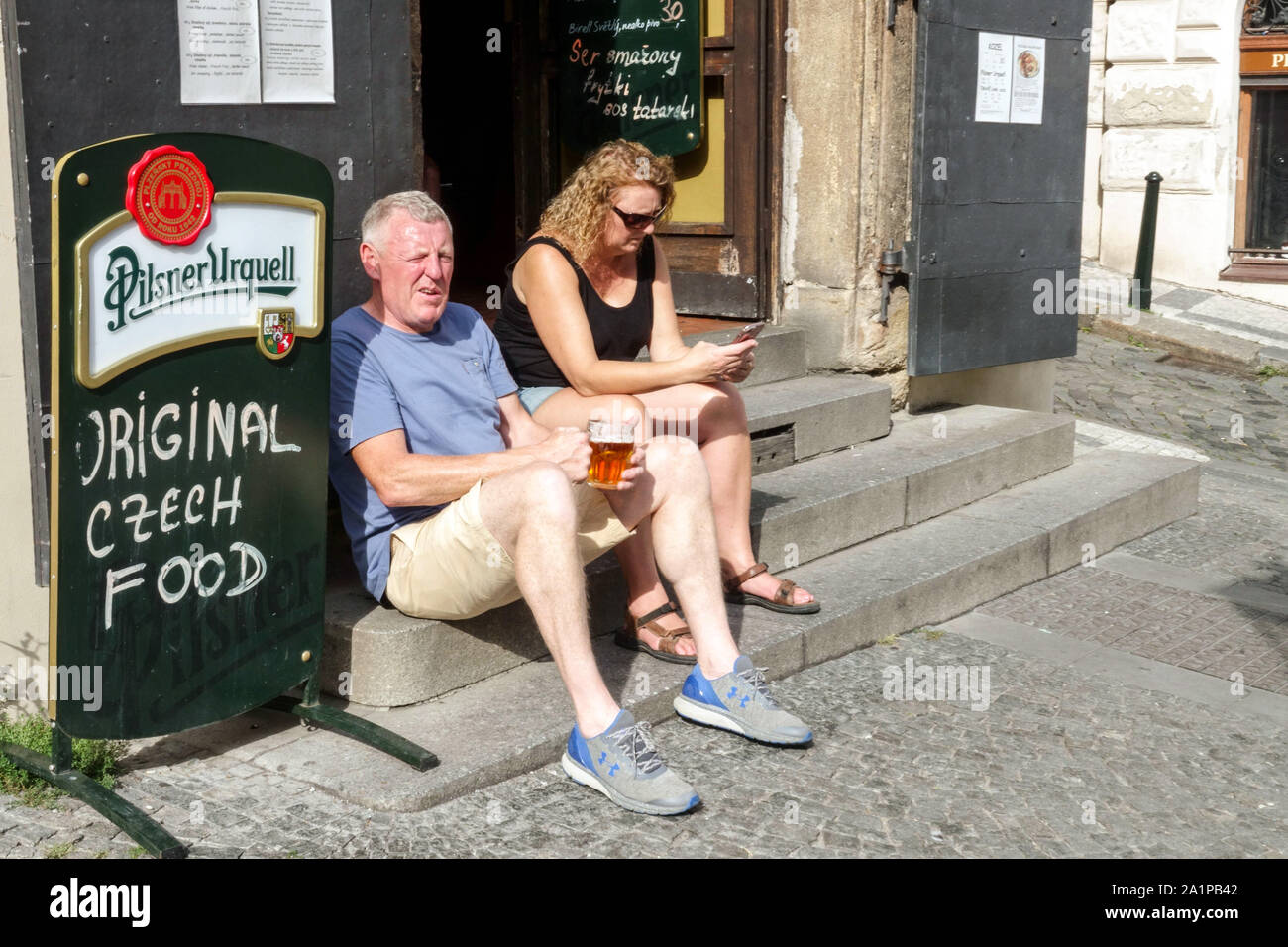 Turisti di Praga bere birra fuori bar U Kocoura in estate calda, Praga Mala Strana Praga Turismo Repubblica Ceca Foto Stock