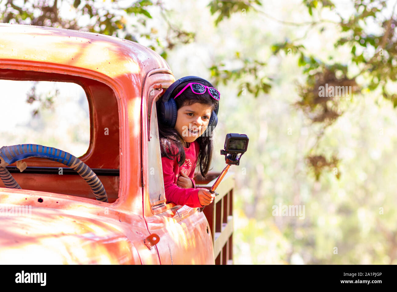 Bambina di scattare una foto con una fotocamera di azione Foto Stock