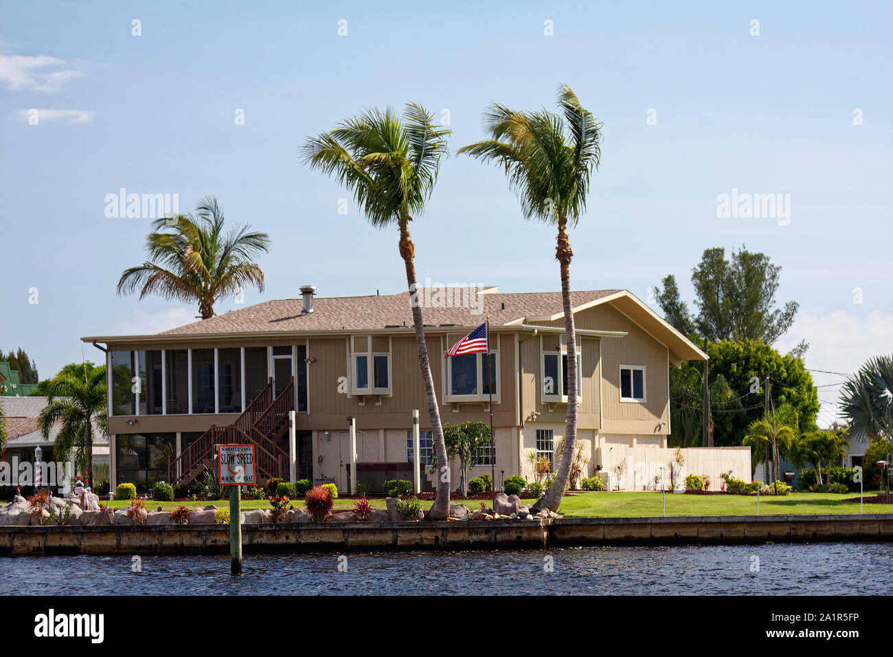 Casa, Waterfront, Intracoastal Waterway, 2 story, schermatura upper deck, noi battenti bandiera, un paesaggio attraente, palme, Southwest Florida, FL, SPR Foto Stock