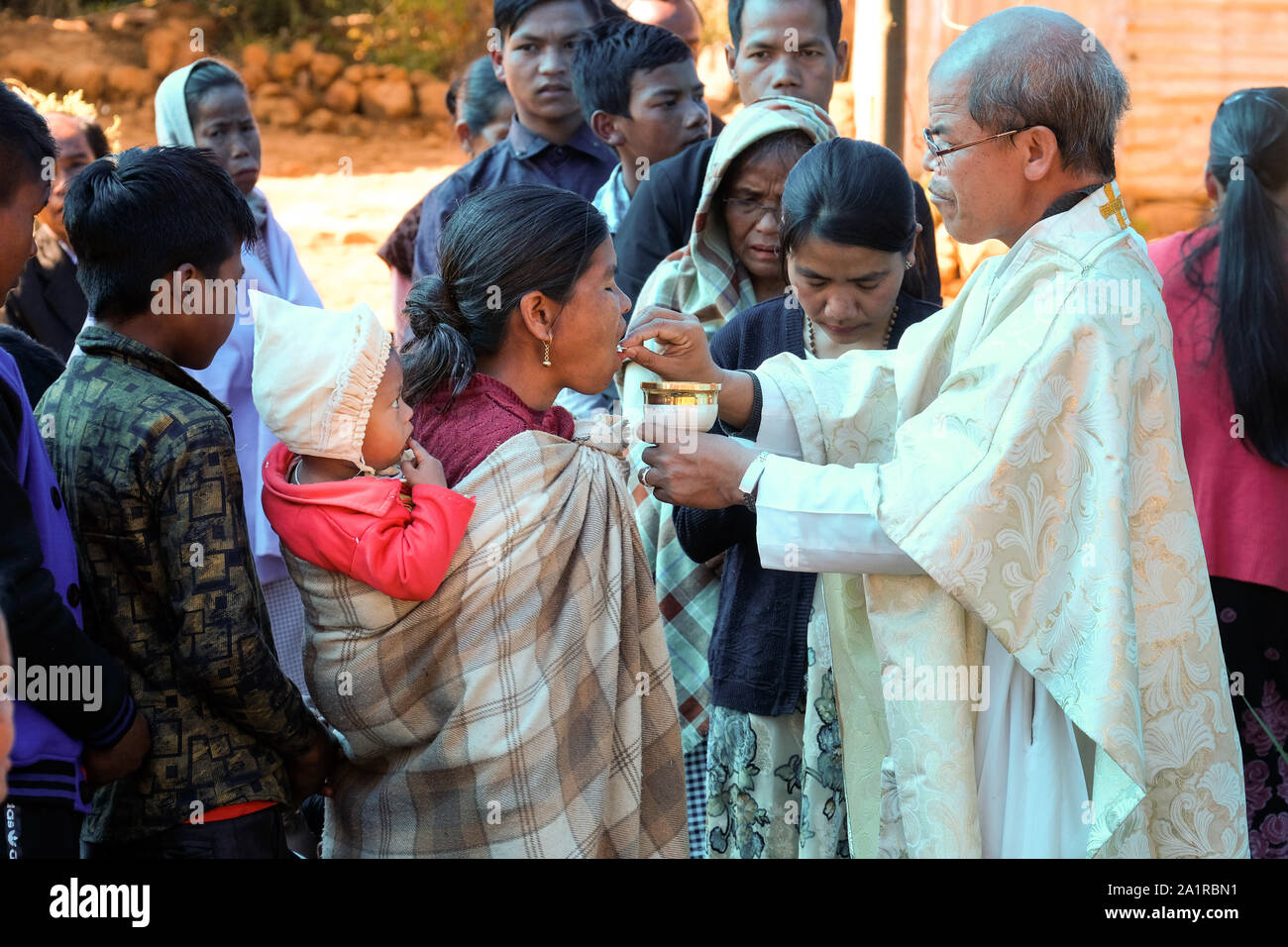 Sacerdote cattolico dà la santa Comunione Eucaristica durante un cattolico la messa domenicale di persone provenienti da minoranze etniche tribù Khasi nel villaggio di Jarain in Khasi Hills, nello Stato di Meghalaya, India Foto Stock