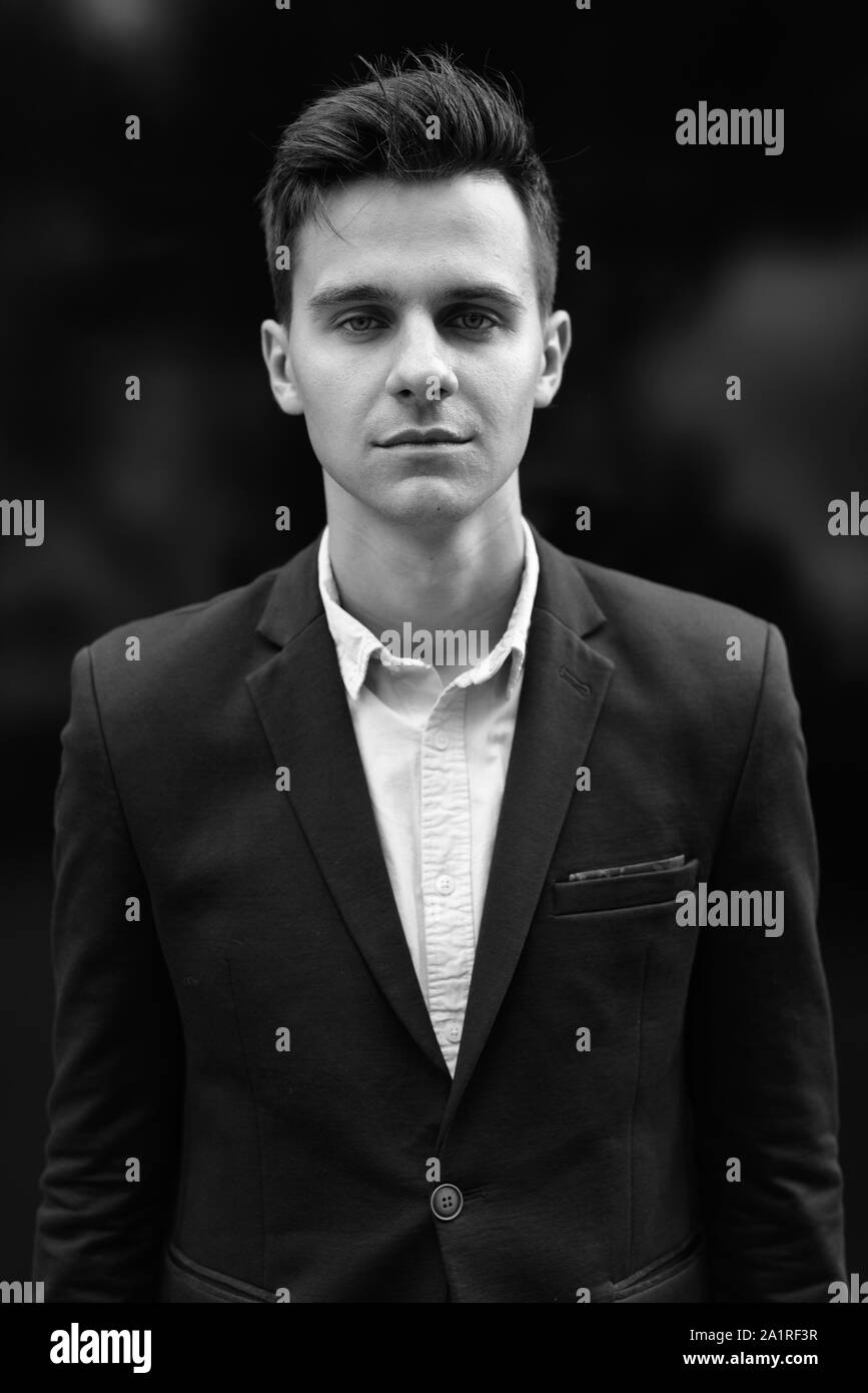 Ritratto di giovane imprenditore bello all'aperto girato in bianco e nero Foto Stock