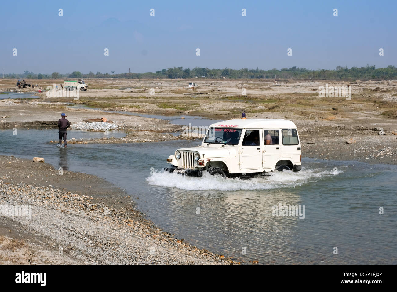 Unità auto attraverso un fiume a Ambagon, stato di Assam, in India Foto Stock