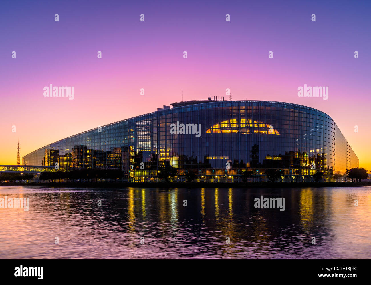 Twilight vista in una luce color porpora dell'orientale facciata di vetro dell'edificio Louise Weiss a Strasburgo la sede del Parlamento europeo a Strasburgo, in Francia. Foto Stock