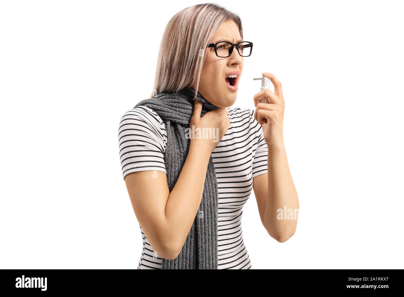 Giovane donna che soffre di un'allergia la spruzzatura di un farmaco e tenendo la sua gola isolati su sfondo bianco Foto Stock