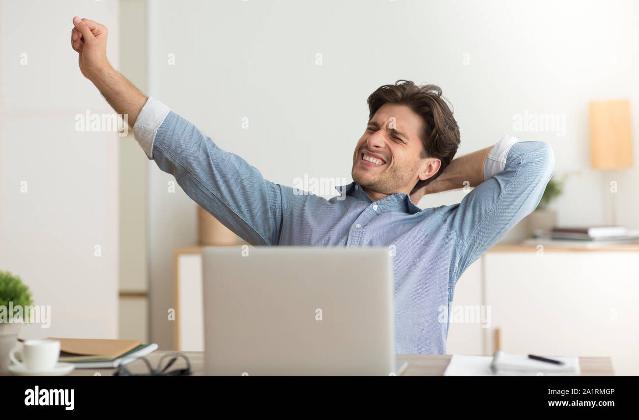Man mano stiro Excercising stanco della seduta di lavoro in ufficio Foto Stock