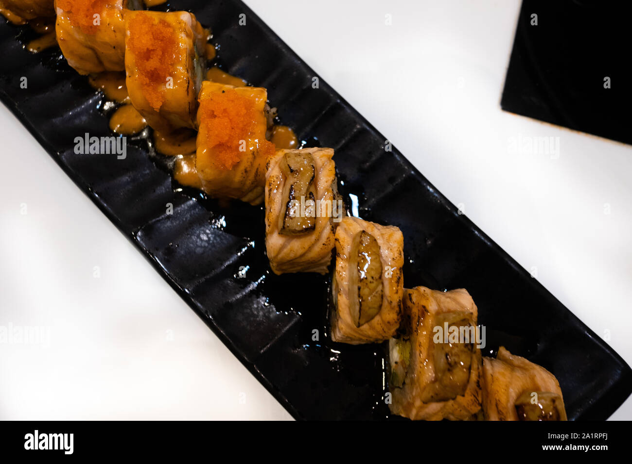 Sushi di salmone servite sul piatto nero Foto Stock