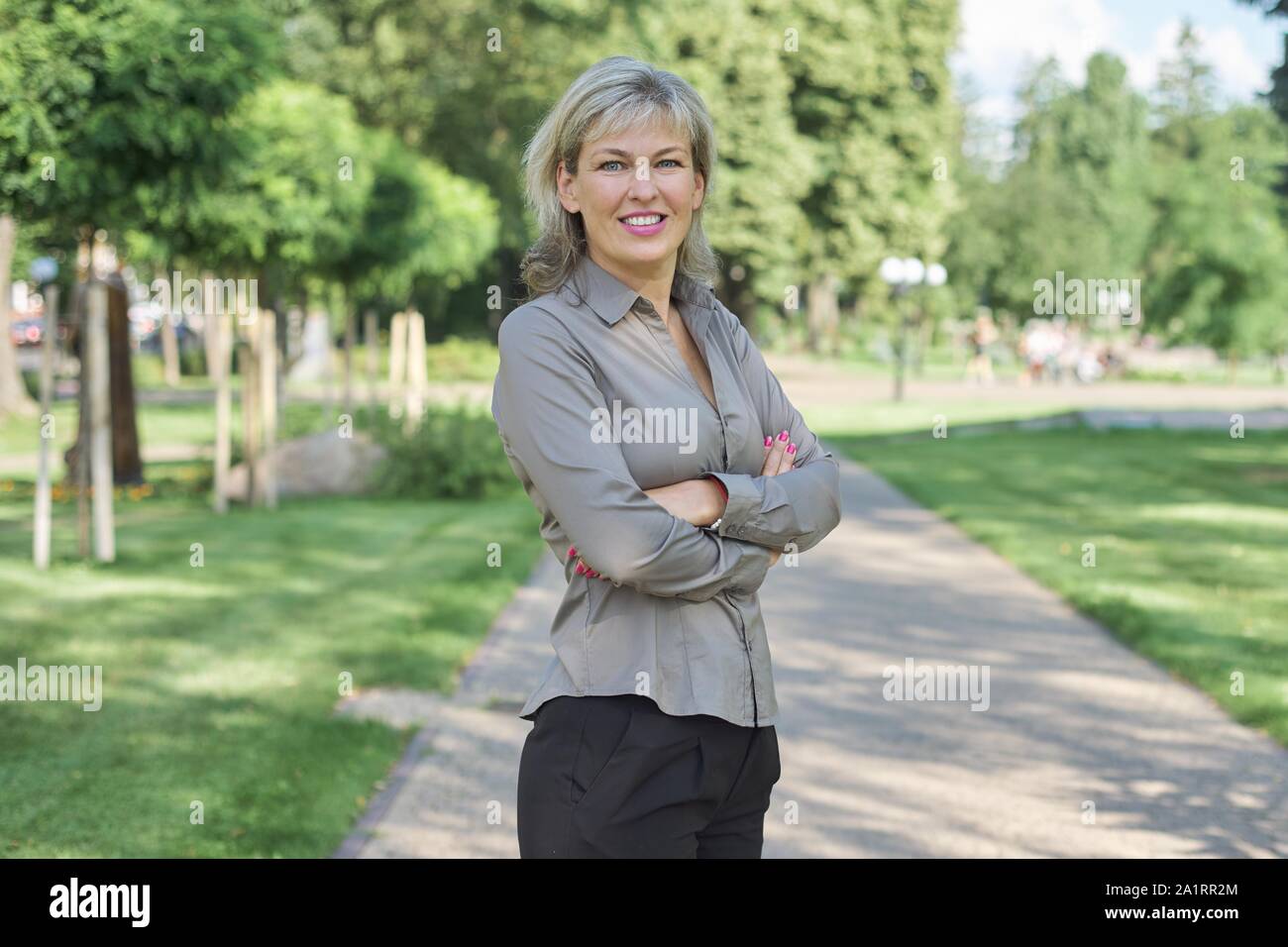 Ritratto esterno positivo della coppia di mezza età della donna, femmina con le braccia incrociate, bel sorriso, sfondo via della città Foto Stock